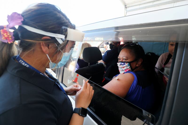 A woman receives the Pfizer shot at a drive-through Covid-19 vaccination clinic in Otara, south Auckland, New Zealand. Photo: Reuters