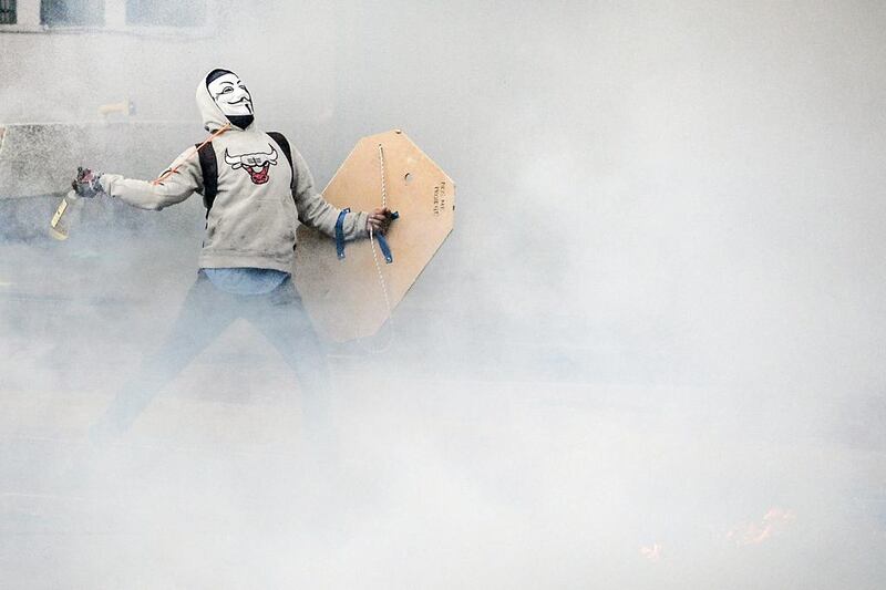 An opposition activist throws a Molotov cocktail in clashes with riot police in Caracas, Venezuela. Luis Robayo / AFP Photo