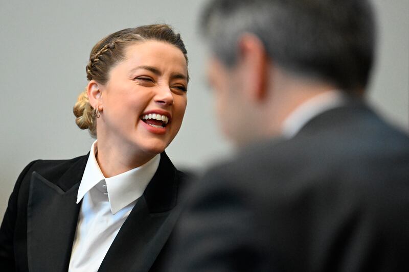 Amber Heard speaks with her lawyers at the defence table. AP