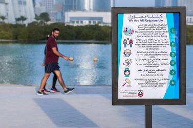 A sign at Reem Beach reminds residents exercising to be responsible amid the coronavirus outbreak. Victor Besa/The National