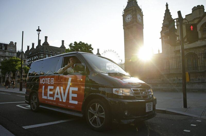 A man in a vehicle sporting a Vote Leave logo blows a kiss as he drives through Parliament Square in London. Matt Dunham/ AP