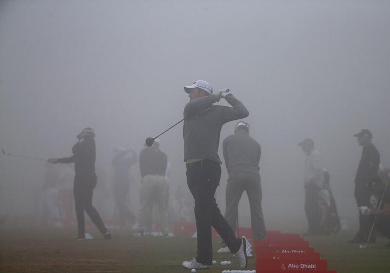 Golfers hit balls at the driving range on Friday during the Abu Dhabi HSBC Golf Championship second round delay. Karim Sahib / AFP