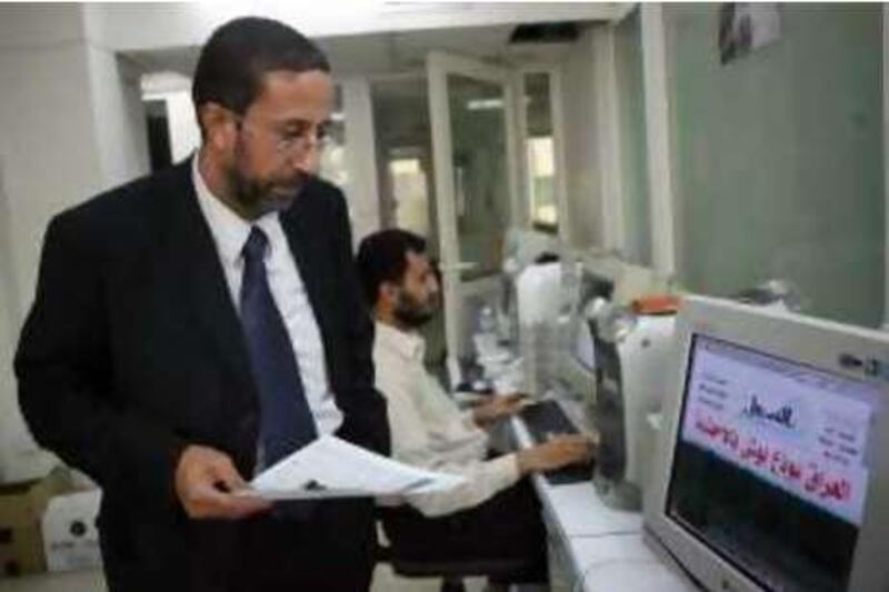Al-Sabeel newspaper's Editor-in-Chief Atef Joulani  checks on work at the offices in the newspaper in Amman, Jordan December 21, 2008. The headline on the computer screen reads: Iraq bids Bush farewell with shoes"
(Salah Malkawi/ The National) *** Local Caption ***  SM006_Newspaper.jpg