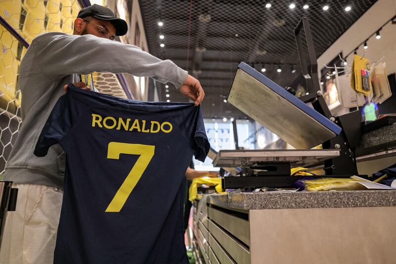 A staff member shows the jersey of Al Nasr's new signing Cristiano Ronaldo. AFP