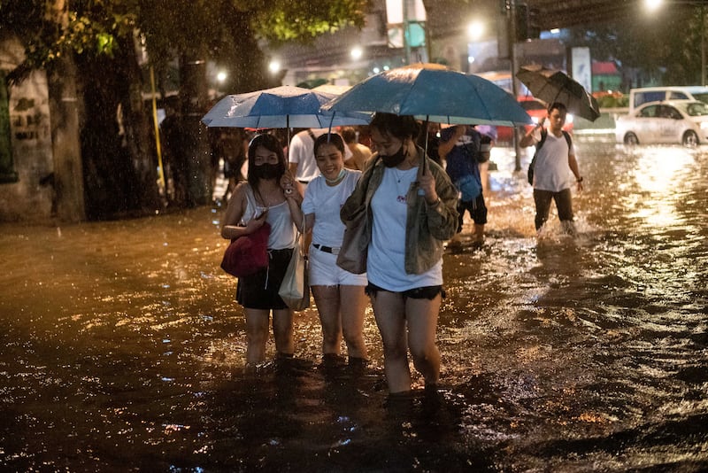 People wade through floodwater in Manila. Reuters