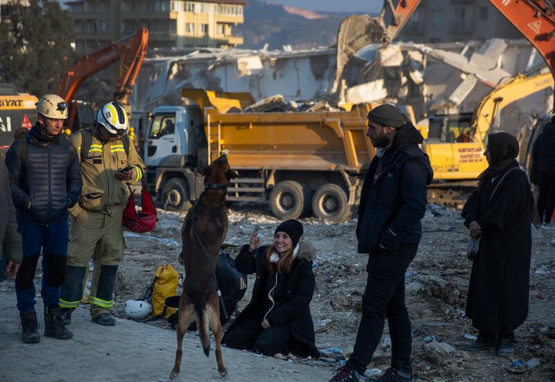 A woman plays with a sniffer dog in Antakya, Turkey. AP