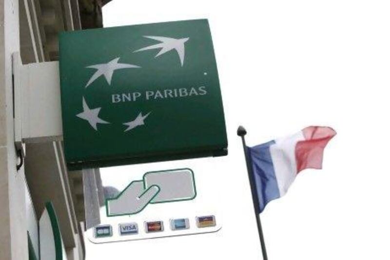 A French flag flies next to a BNP Parisbassign in Paris.