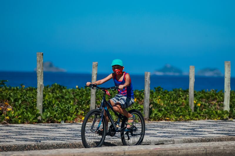 A boy rides a bike along the Ipanema beach  in Rio de Janeiro, Brazil.