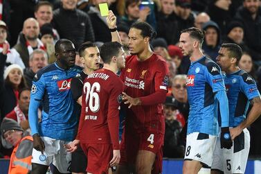 Spanish referee Carlos del Cerro Grande shows a yellow card to Liverpool's Scottish defender Andrew Robertson and Napoli's Senegalese defender Kalidou Koulibaly (L) at Anfield. AFP