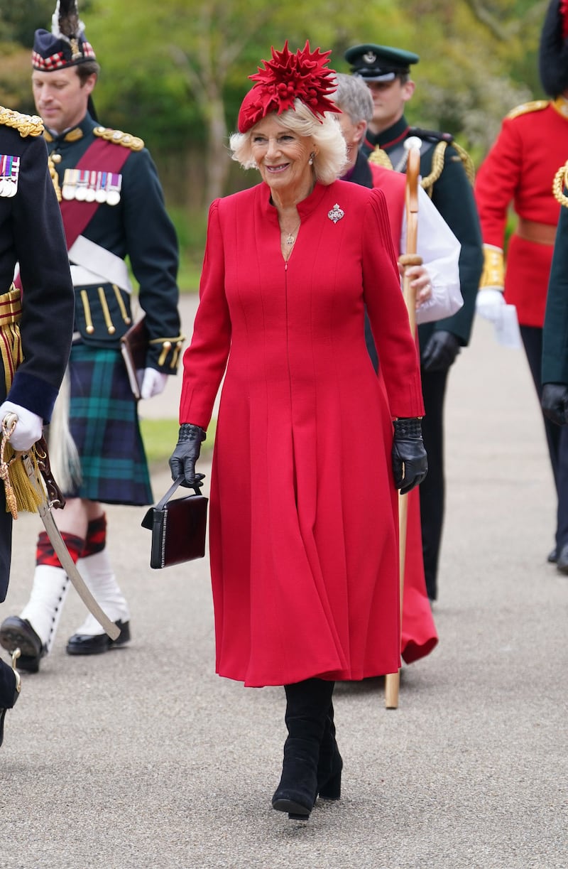 The queen consort in a red coat dress by Fiona Clare and a striking beret by Philip Treacy at a Royal Navy ceremony in April 2023. AFP