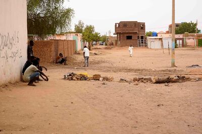 Youths sit by a wall next to a brick roadblock in Omdurman, Khartoum's twin city, in war-torn Sudan, on May 29, 2023.  AFP