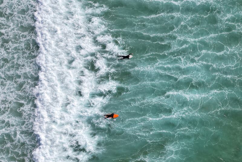 People surfing in the sunshine, with the warm weather set to continue into the weekend, at Fistral Beach, Newquay, south-west Britain. Reuters