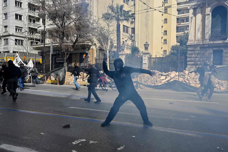A protester throws a projectile during clashes with police at a demonstration in Athens, following the train crash. AFP