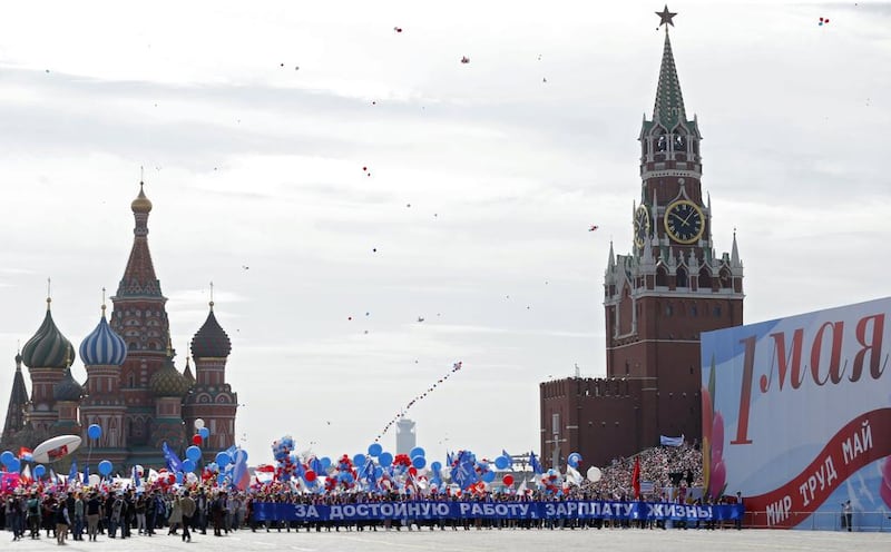 Russian marchers carry a banner reads as ‘For decent work, salary, life!’ in front of St Basil’s Cathedral and Spaskaya Tower during a rally at Red Square in Moscow. Sergei Ilnitsky / EPA
