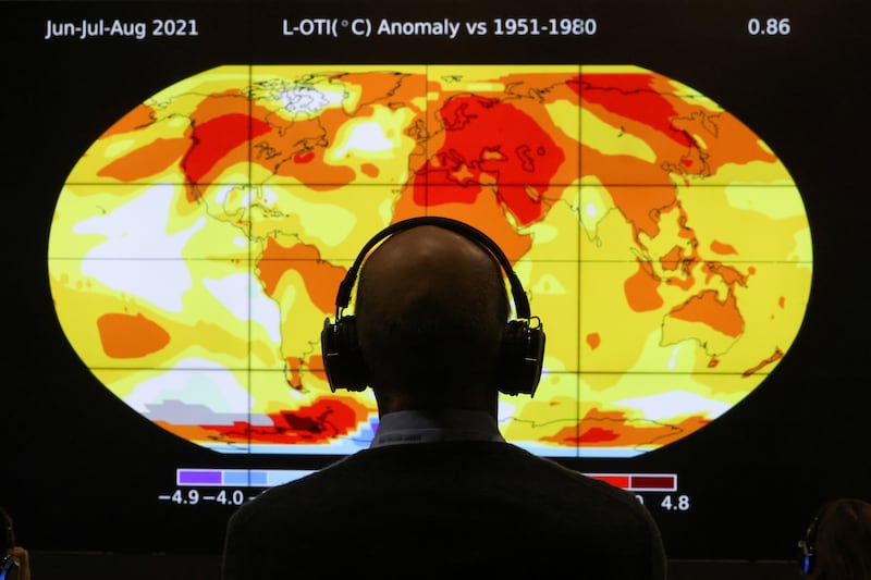 A delegate views a screen displaying global temperatures. Reuters