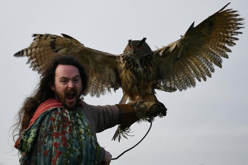 The Druid Malachy, played by Ciaron Davies, reacts with a European eagle-owl named 'Cracker' during a re-enactment of the first landing of Saint Patrick in Ireland at Inch Abbey in Downpatrick, Northern Ireland. Clodagh Kilcoyne / Reuters
