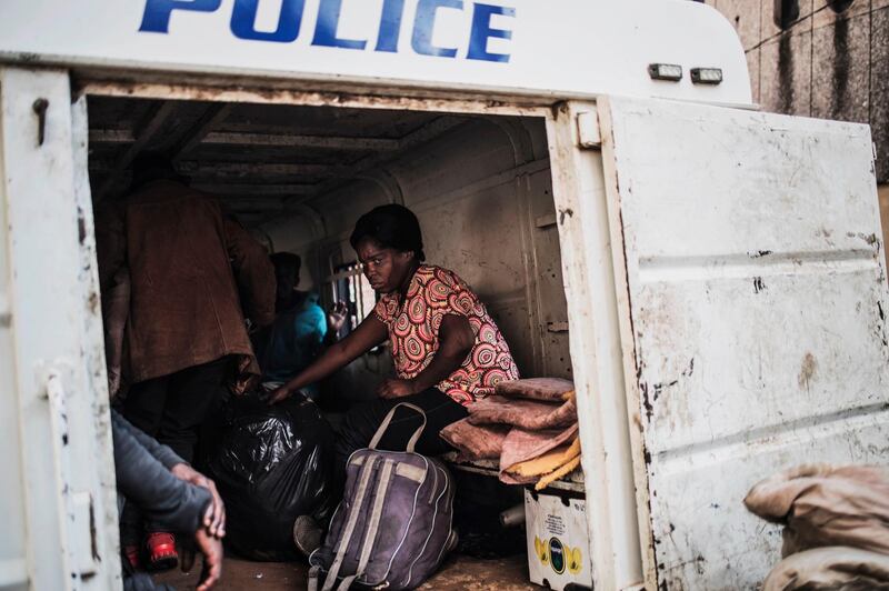 A pregnant homeless woman sits inside a police van in Johannesburg after having been rounded up by Johannesburg Metro Policemen. AFP