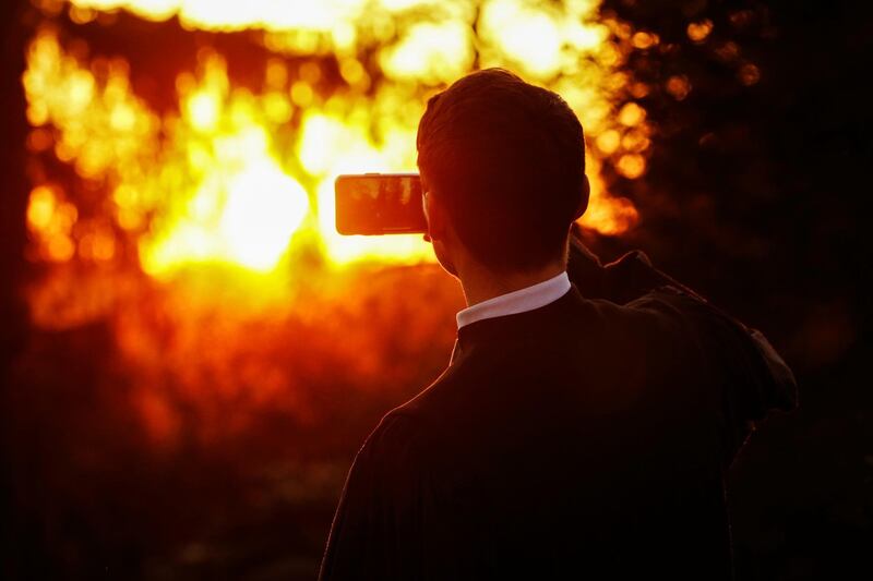 Pastor Viktor Weber films with his mobile phone as he celebrates the resurrection of Jesus Christ on Easter Sunday at a cemetery in Berlin. Reuters