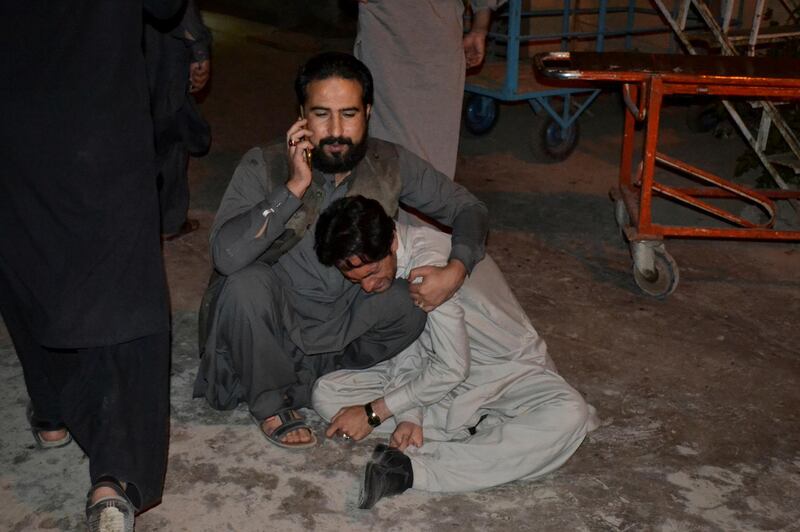 A man comforts another who mourns the death of a relative after an explosion at a luxury hotel, at a hospital in Quetta, Pakistan. Reuters
