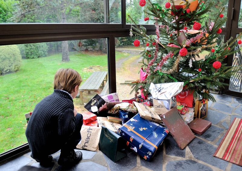 (FILES) In this file photo taken on December 25, 2013 A young boy discovers his presents under the Christmas tree in Dinan, northwestern France. Lockdown: the toy industry between worry and hope as Christmas approaches. / AFP / PHILIPPE HUGUEN
