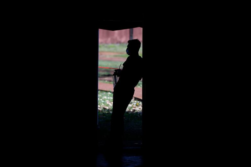 A youth drinks mate, a traditional herbal drink, as he looks out from the door of a gym at a school being used as a government-run quarantine shelter in Ciudad del Este, Paraguay. AP Photo