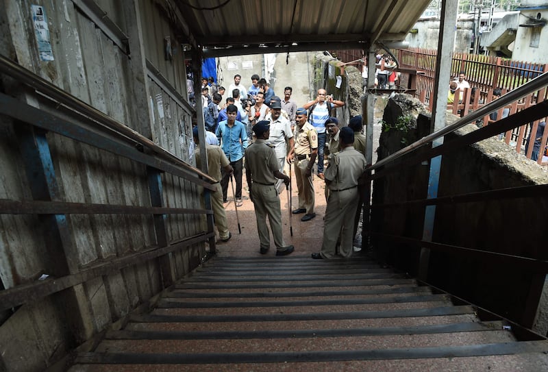 Indian security personnel and media gather at the scene of a stampede on a railway bridge in Mumbai. AFP