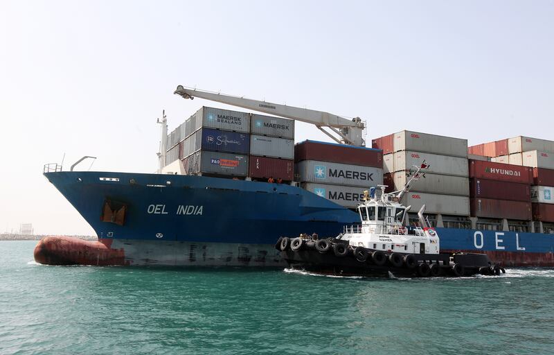 DUBAI , UNITED ARAB EMIRATES Ð Oct 06 : Tugboat pushing the Cargo ship at the entrance of Jebel Ali port in Dubai. ( Pawan Singh / The National ) For Business. Story by Frank Kane
