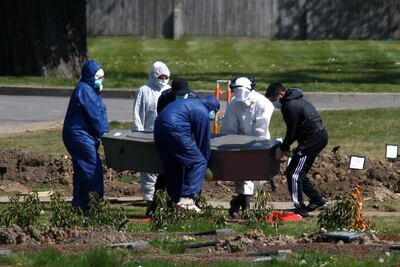 Workers wearing protective suits carry the coffin containing the body of a person at the Muslim cemetery Eternal Gardens in Kemnal Park Cemetery in Chislehurst, as the spread of the coronavirus disease (COVID-19) continues, London, Britain April 23, 2020. REUTERS/Henry Nicholls