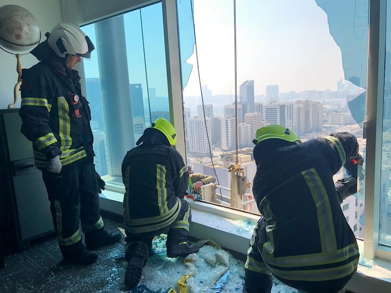 Police break a window to rescue two window cleaners trapped outside the building in Al Wahda. Courtesy Abu Dhabi Police