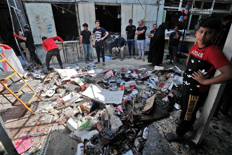 Iraqis at the site of a suicide bombing at a market in Sadr City, Baghdad. AFP