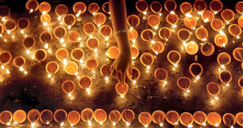 A devotee lights oil lamps at a religious ceremony during the Diwali or Deepavali festival at a Hindu temple in Colombo, Sri Lanka October 18, 2017. REUTERS/Dinuka Liyanawatte     TPX IMAGES OF THE DAY - RC1718C64370