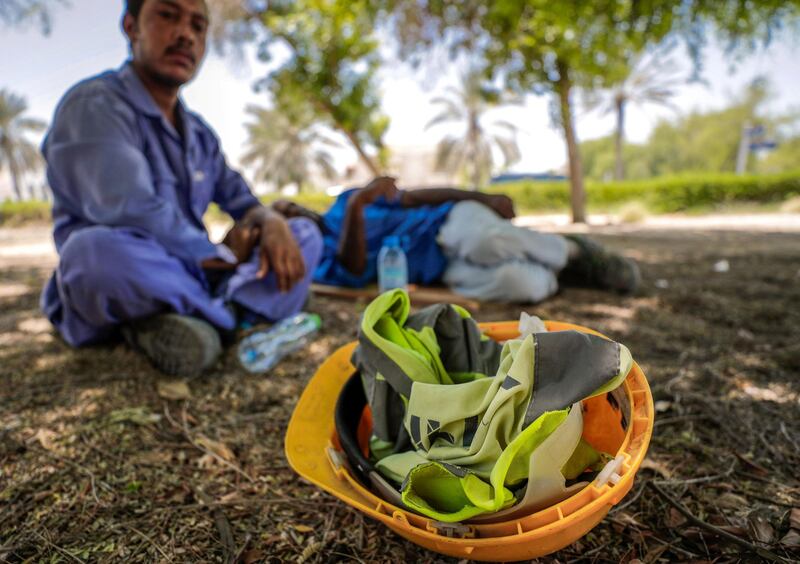 Abu Dhabi, United Arab Emirates, June 15, 2019.  
The UAE's mandatory midday break for people working outdoors during the summer months will come into force on Saturday. --  Pakistani workers take refuge under the shade of a tree along Al Dhafra street.
Victor Besa/The National
Section:  NA
Reporter: