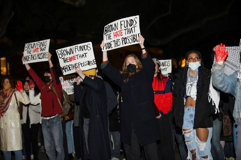 Protesters hold up signs following the vigil at Brown University. Reuters