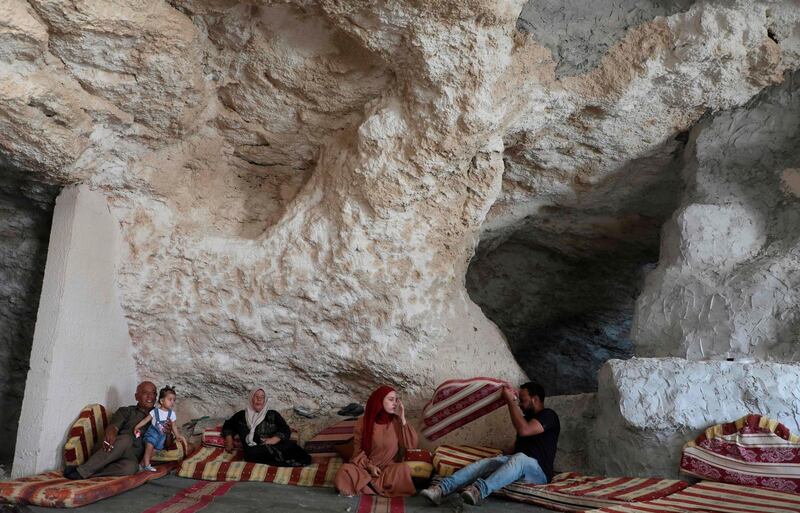 Ahmed Amarneh and his family members relax in his cave home. AFP