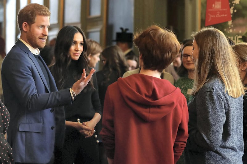 Britain's Prince Harry (L) and his fiancée US actress Meghan Markle (2nd L) attend a reception for young people in the Palace of Holyroodhouse in Edinburgh, during their visit to Scotland on February 13, 2018. - The reception celebrates youth achievements, marking Scotland’s Year of Young People 2018, an initiative that aims to inspire Scotland through its young people: celebrating their achievements, strengthening their voice on social issues and creating new opportunities for them to shine. (Photo by Andrew Milligan / POOL / AFP)