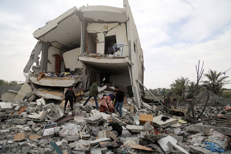 People inspect damage and recover items from their homes after Israeli air strikes on March 16 in Nuseirat, Gaza Strip. Reuters