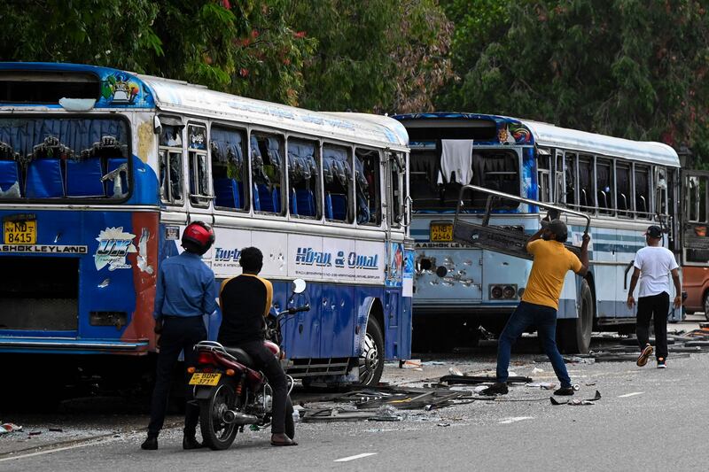 Anti-government protesters destroy a bus in Colombo. AFP