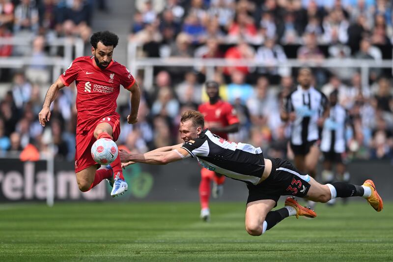 Dan Burn of Newcastle tackles Mohamed Salah. Getty