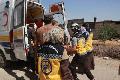 Members of the Syrian White Helmets civil defence volunteer force carry away the wounded after an attack in Idlib province.