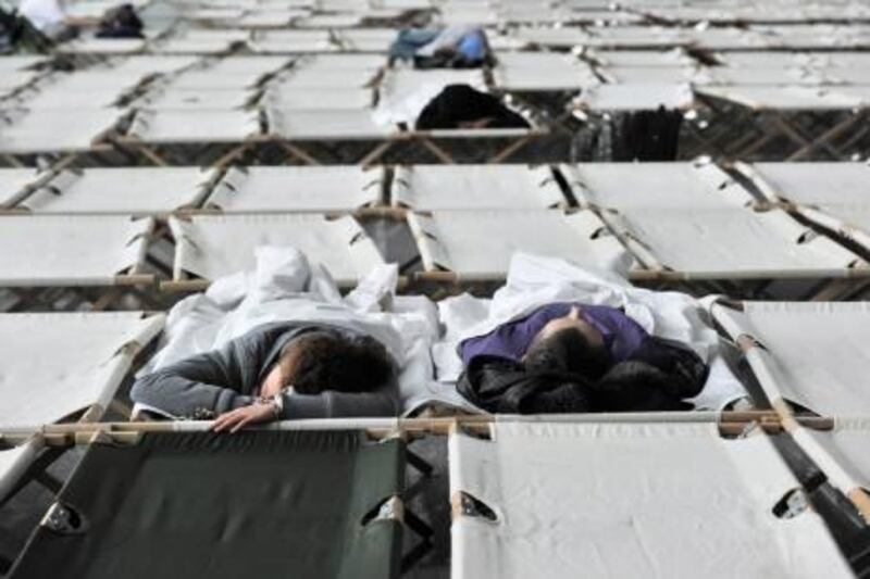 epa02501412 Passengers sleep on camp beds at Frankfurt airport, Germany, on 19 December 2010. Snowfall and icy conditions continued to hamper European air travel, including hundreds of flight cancellations at Frankfurt airport, a major international hub.  EPA/BORIS ROESSLER *** Local Caption ***  02501412.jpg