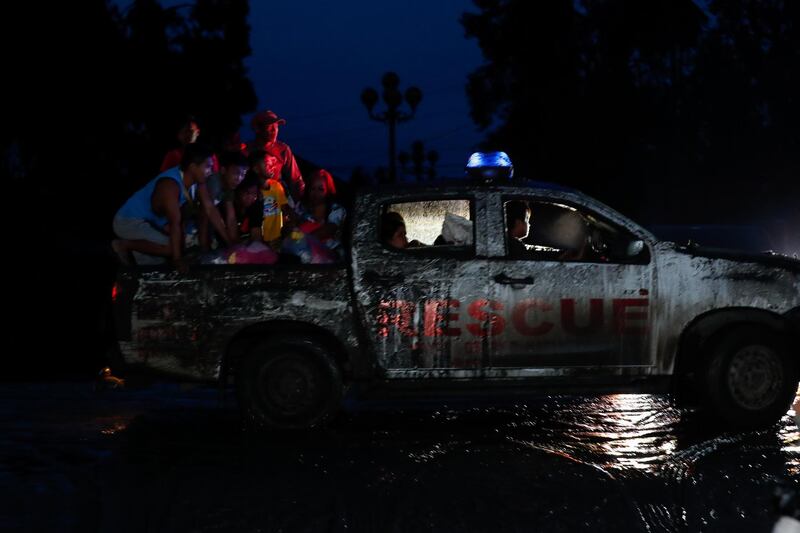 Villagers ride a rescue vehicle after a volcano eruption in Talisay, Batangas. EPA
