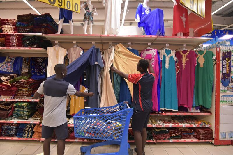 Men look at clothes at the Carrefour supermarket in Abidjan, Ivory Coast.  on the eve of the start of the Ramadan, the Muslim holy month of fasting.  AFP