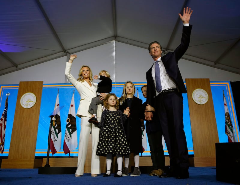 Ms Siebel Newsom and Mr Newsom wave after the California governor takes the oath of office in 2019. AP