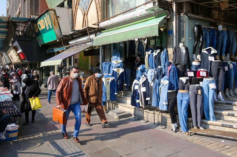 (FILES) In this file photo Iranians wearing protective masks amid the COVID-19 pandemic, walk on a market street in the capital Tehran, on December 30, 2020. Iran has commuted the sentence of an ailing 84-year-old Iranian-American but barred him from leaving, his son said on February 22, 2021, urging President Joe Biden to prioritize the case. Baquer Namazi, a former UNICEF official, was detained in February 2016 when he traveled back to Iran after the arrest in Tehran of his son Siamak Namazi, a businessman.Siamak's brother, Babak, revealed that the Iranian judiciary commuted the sentence to time served a year ago based on his serious medical problems.
 / AFP / ATTA KENARE
