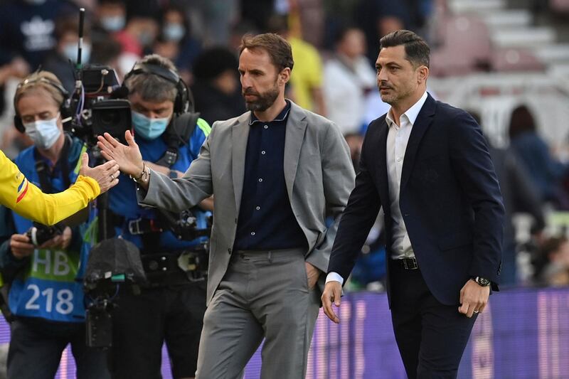 England's coach Gareth Southgate, left, leaves the pitch with Romania's coach Mirel Radoi. AP