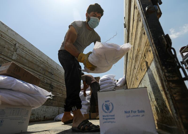 A worker unloads bags and boxes of humanitarian aid from the back of a truck in the opposition-held Idlib, Syria June 9, 2021. Picture taken June 9, 2021. REUTERS/Khalil Ashawi