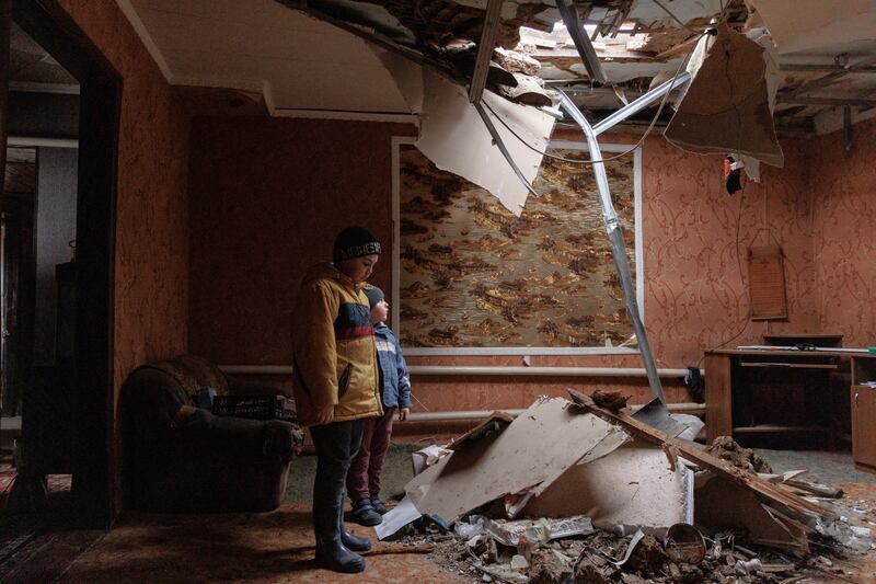 Marat and Renat Bonderenko in the living room of their neighbours' house, which was hit during Russia bombardment of the village of Yakovlivka outside Kharkiv, Ukraine. Reuters