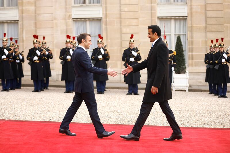 Mr Macron and Sheikh Tamim shake hands. EPA