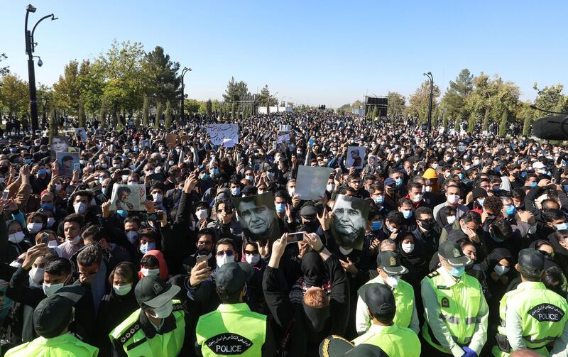 Fans raise portraits of Mohammad Reza Shajarian during his funeral. AFP