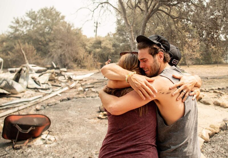 Resident Austin Giannuzzi cries while embracing family members at the burned remains of their home in Vacaville, California.  AFP